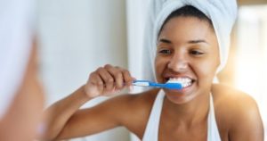 A woman brushing her teeth and gums