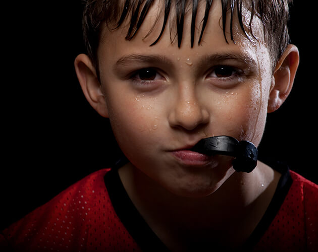 Close up shot of a child biting on sports mouthguard