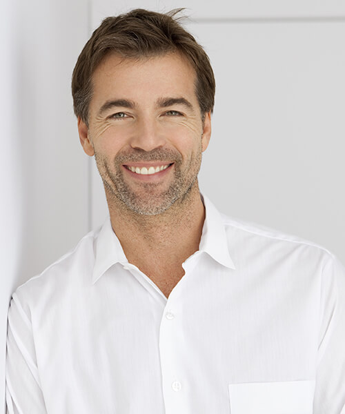 Middle age man wearing white shirt smiling indoors