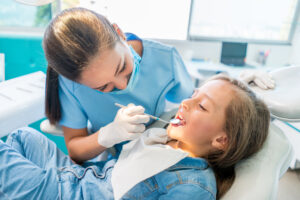 Girl at the dentist getting a check up on her teeth